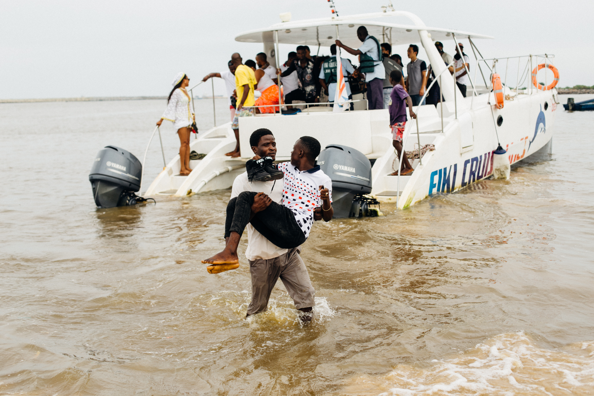 Man carrying a visitor to Tarkwa Bay above water