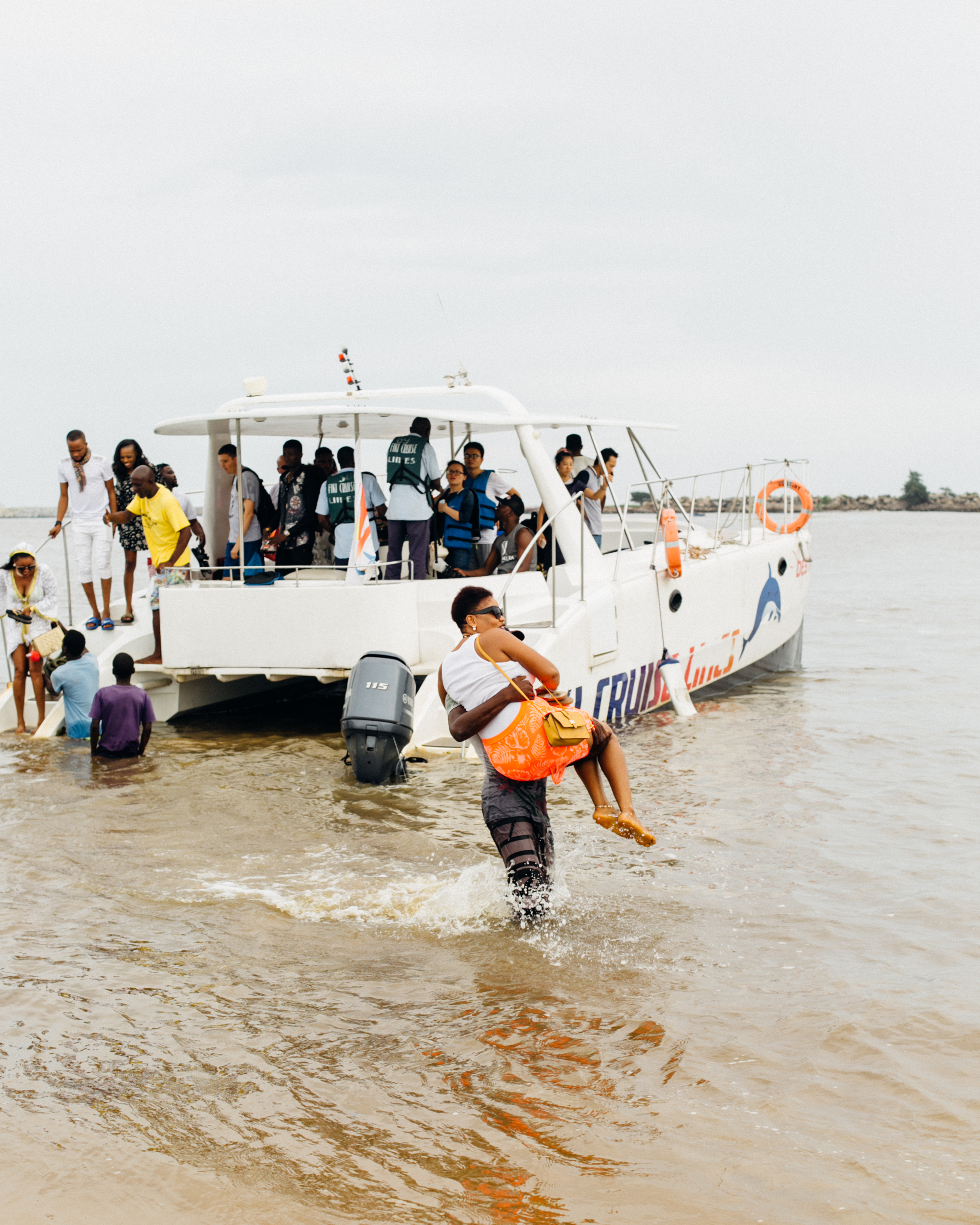 Man carrying a visitor to Tarkwa Bay above water