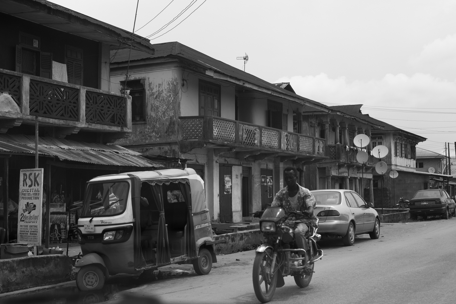 Motorcycle passing by colonial buildings in Sapele